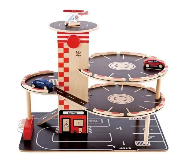 Hape Parkhaus Spielset wooden three-level parking garage with ramps, toy cars, and helicopter for kids.